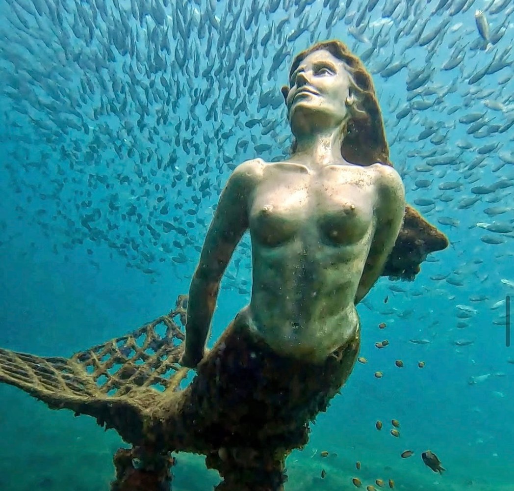 a statue of a person in a pool of water